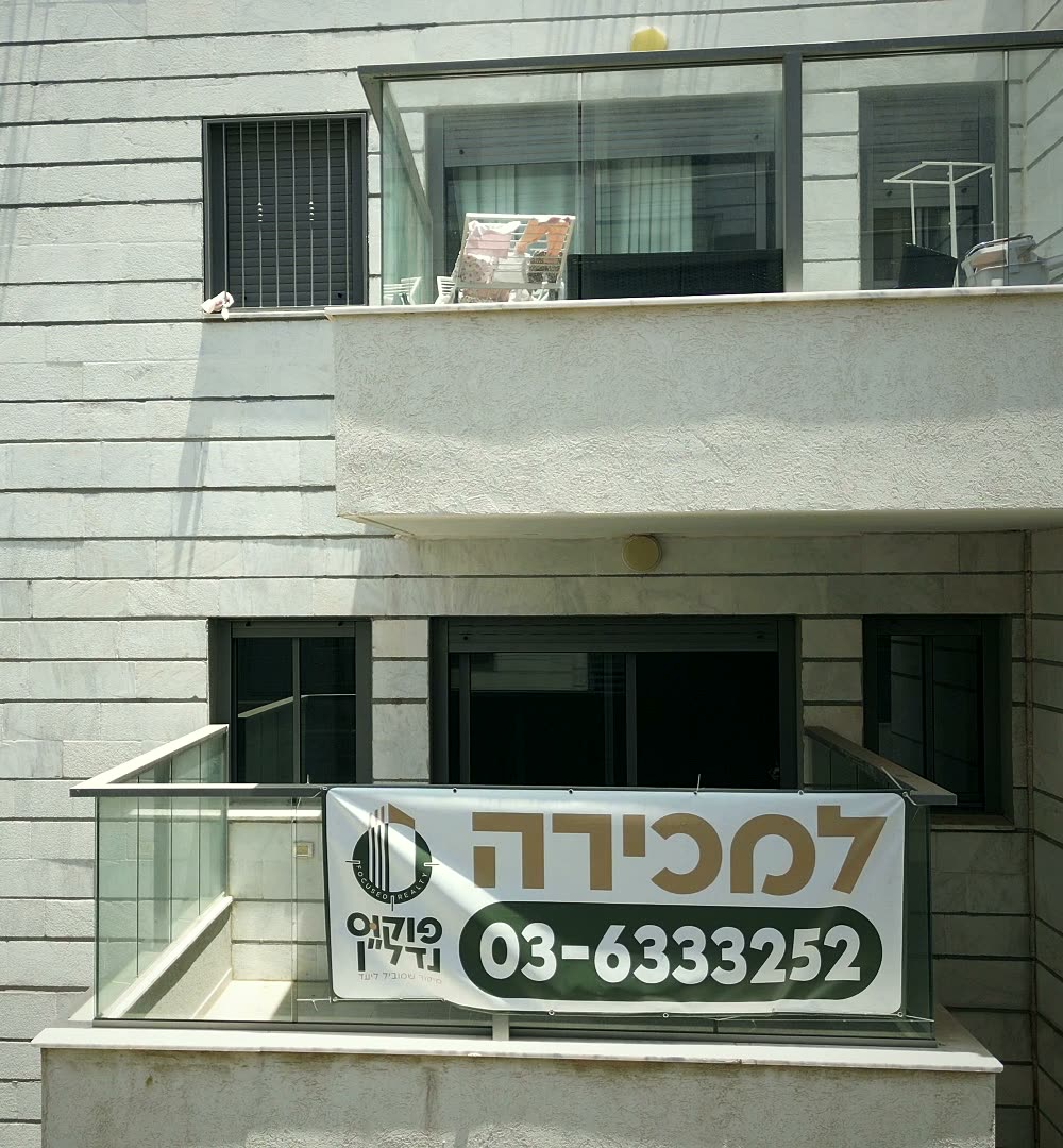 שלט למכירה של פוקוס נדל״ן על מרפסת במתחם